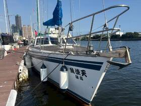 A detailed view of a yacht docked at a marina, showcasing its sleek design and surrounding urban landscape.