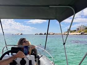 A woman enjoys a scenic boat ride, taking in the beautiful ocean views and rocky coastline — perfect for a relaxing day on the water.