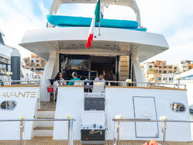 Guests enjoy a relaxed atmosphere aboard a luxurious yacht, showcasing the elegant interior seating area perfect for social gatherings.