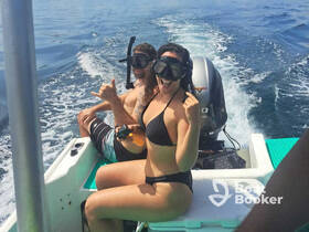 A couple enjoys a fun snorkeling adventure on a boat, showcasing the excitement of ocean exploration and water activities.