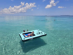 Two young boys enjoy a sunny day on a floating mat in crystal-clear waters, capturing the essence of summer fun and relaxation.