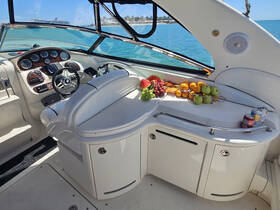 A well-appointed helm area inside a boat, featuring a comfortable seating arrangement and a selection of fresh fruits and drinks, perfect for a relaxing day on the water.
