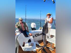 Two anglers proudly display their catch aboard a fishing boat, showcasing a successful day on the water. Perfect for fishing enthusiasts looking for adventure.