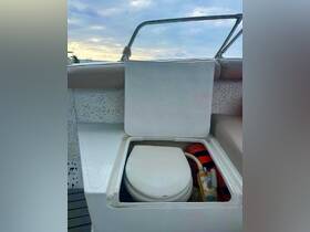An interior view of a boat's bathroom area, showcasing the toilet and plumbing setup — essential for comfort during boating trips.