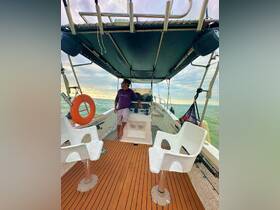 A man stands at the helm of a boat, showcasing the interior seating and helm area, perfect for navigating the open waters.