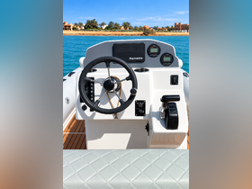 A detailed view of the helm and console of a boat, showcasing modern navigation equipment and a sleek design, perfect for boating enthusiasts.