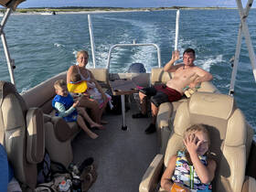 A joyful family enjoys a relaxing day on a boat, with kids playing and having fun in the sun — perfect for memorable family outings on the water.