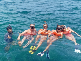 A lively group enjoys snorkeling in clear waters, showcasing the fun and excitement of underwater exploration.