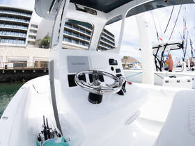 A detailed view of the helm and console area inside a boat, showcasing modern navigation equipment and seating, perfect for fishing or leisure trips.