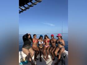 A fun group of friends enjoys a day on the water, posing in their bikinis aboard a boat, perfect for fishing and sun-soaked adventures.