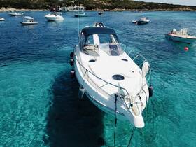 A stunning aerial view of a yacht anchored in crystal-clear waters, surrounded by other boats, showcasing the beauty of a serene maritime environment.