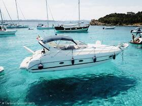 A sleek speedboat anchored in crystal-clear turquoise waters, surrounded by other vessels, showcasing the beauty of a perfect boating day.