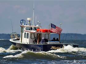 A fishing boat named 'Night' navigates through choppy waters, showcasing its American flag and fishing gear — perfect for a day on the water.