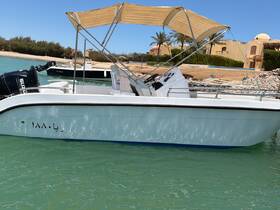 A clear side view of a boat docked in tranquil waters, showcasing its sleek design and structure — perfect for day trips or fishing excursions.