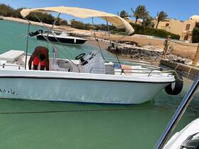 A man is seen preparing the interior of a boat, showcasing the helm and seating area, perfect for a day out on the water.