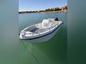 A sleek boat docked in calm waters, showcasing its clean lines and inviting design — perfect for leisurely outings or fishing trips.