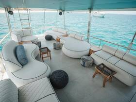 Stylish and spacious lounge area inside a boat, featuring comfortable seating and a stunning view of the turquoise waters — perfect for relaxation during your nautical adventures.