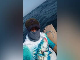 A person is seen on a boat, ready for a fishing adventure on the open water, showcasing the thrill of outdoor activities.