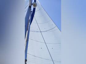A close-up view of a sail on a yacht, showcasing the intricate details of the fabric against a clear blue sky — perfect for sailing enthusiasts.