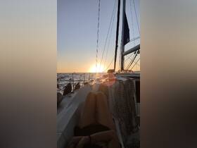 A serene sunset view from a sailboat, with a guest relaxing on the deck — an ideal moment for unwinding and enjoying the beauty of the open water.