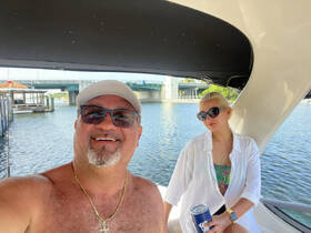 A couple enjoys a relaxing moment on a boat, sipping drinks and soaking in the sun — perfect for a day out on the water.