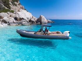 A stylish boat anchored in crystal-clear turquoise waters near a rocky coastline, perfect for exploring hidden gems and enjoying a day on the water.