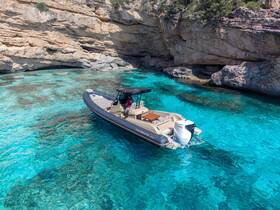 A sleek speedboat navigates through crystal-clear turquoise waters, showcasing the stunning coastal cliffs in the background — perfect for exploring hidden coves.
