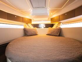 Cozy interior of a boat cabin featuring a round bed and elegant lighting, perfect for relaxing during your nautical adventures.