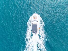 Aerial view of a sleek yacht cruising through vibrant turquoise waters, showcasing the perfect setting for a day on the water.