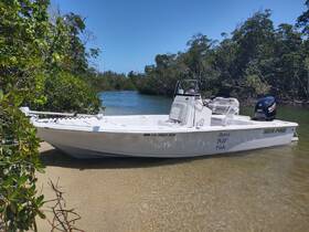 A pristine Sea Pro boat docked in shallow waters surrounded by lush greenery, perfect for fishing or leisurely outings.