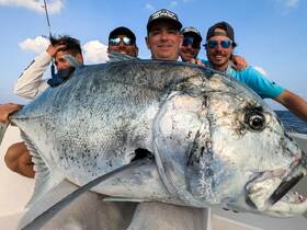 A group of friends proudly displays their impressive catch while fishing, showcasing the thrill of a successful day on the water.