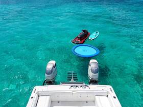 A vibrant scene showcasing a jet ski, paddleboard, and a floating mat in crystal-clear turquoise waters, perfect for a day of fun and relaxation on the water.