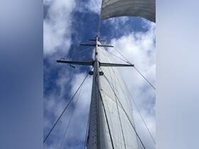 A striking view of a sailboat's mast and sails against a blue sky, showcasing the elegance of sailing and the beauty of the open water.