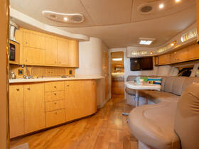 A spacious and elegantly designed interior of a boat featuring a well-equipped kitchen and comfortable seating area, perfect for relaxing during your nautical adventures.