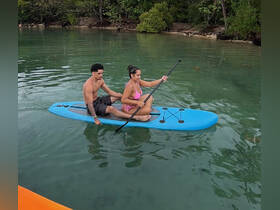 A couple enjoys paddleboarding together in serene waters, showcasing a perfect day of adventure and fun on the water.