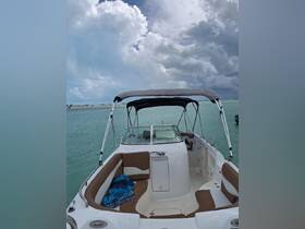 A view of the interior seating area of a boat, showcasing comfortable lounge space and a helm, perfect for relaxing on the water.