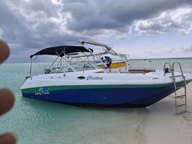 A sleek boat named 'Christina' docked in shallow turquoise waters, perfect for luxury charters and day trips.