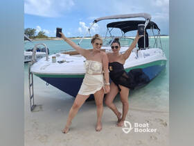 Two friends celebrate on the beach next to their boat, showcasing a fun day in the sun — perfect for beach parties and memorable outings.