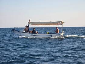 A group of friends enjoys a day on the water aboard a small boat, capturing the essence of summer adventures and on-water fun.
