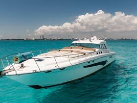 A stunning yacht glides through crystal-clear turquoise waters, showcasing its sleek design against a picturesque backdrop of clouds and distant buildings.