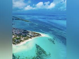 A stunning aerial view of a vibrant coastline with turquoise waters and sandy beaches, showcasing the beauty of the destination — perfect for vacation planning and scenic tours.