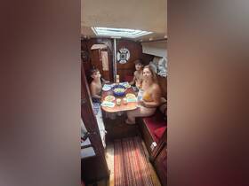 A family enjoys a meal inside the cozy cabin of a boat, showcasing a relaxed dining experience on the water.