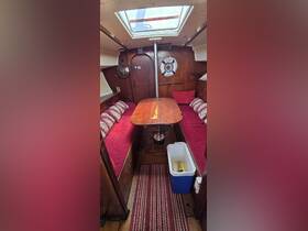 Cozy interior of a boat cabin featuring comfortable seating and a dining table, perfect for relaxing and enjoying meals while on the water.