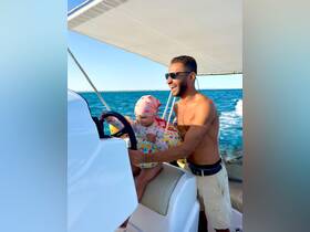 A joyful moment on the water as a child and adult share a laugh while steering a boat, capturing the essence of family fun and adventure at sea.