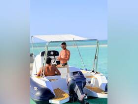 Two friends enjoy a sunny day on a boat, showcasing a relaxed atmosphere perfect for summer outings or water adventures.
