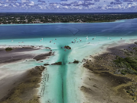 A stunning aerial view of a vibrant coastline with boats navigating through turquoise waters, showcasing the beauty of island life and perfect for adventure seekers.