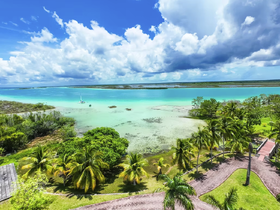 A stunning aerial view of a serene coastline with turquoise waters and lush greenery, perfect for showcasing the beauty of island destinations.