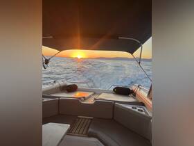A serene view from the interior of a boat, showcasing comfortable seating and a stunning sunset over the water — perfect for relaxing cruises.