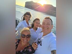 A cheerful group enjoys a sunset selfie on a boat, capturing a memorable moment during their maritime adventure.