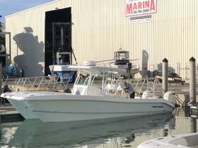 A Twin Vee boat docked at the marina, showcasing its sleek design and features, with a worker preparing it for the day.